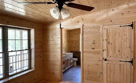 Custom bedroom and bathroom layout in modular log cabin